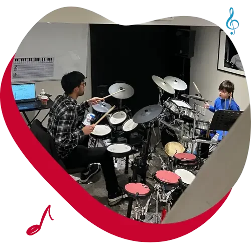 kid having a toronto drum lesson with drum teacher on drum kit